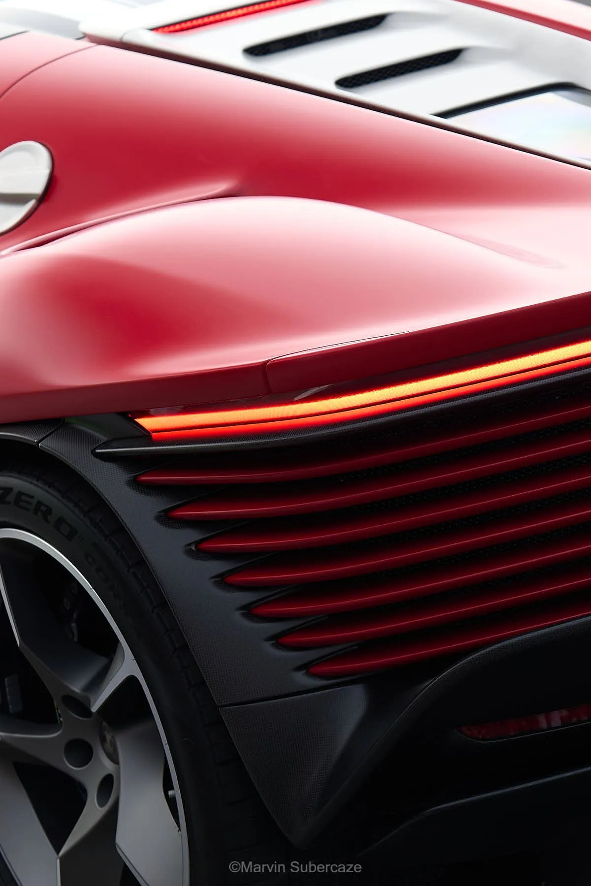 Détail de carrosserie d'une GT rouge, lumière de fin de journée